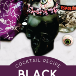 closeup of a black margarita in a skull shaped glass