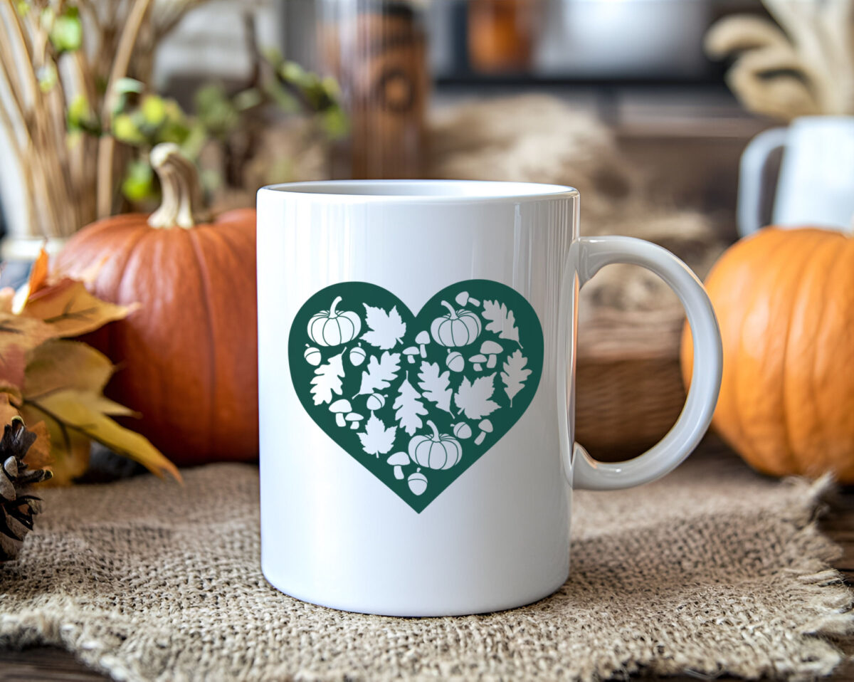 green fall lovers heart design on a coffee mug near pumpkins and fall leaves