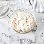 top view of a jar of homemade body butter with the lid open