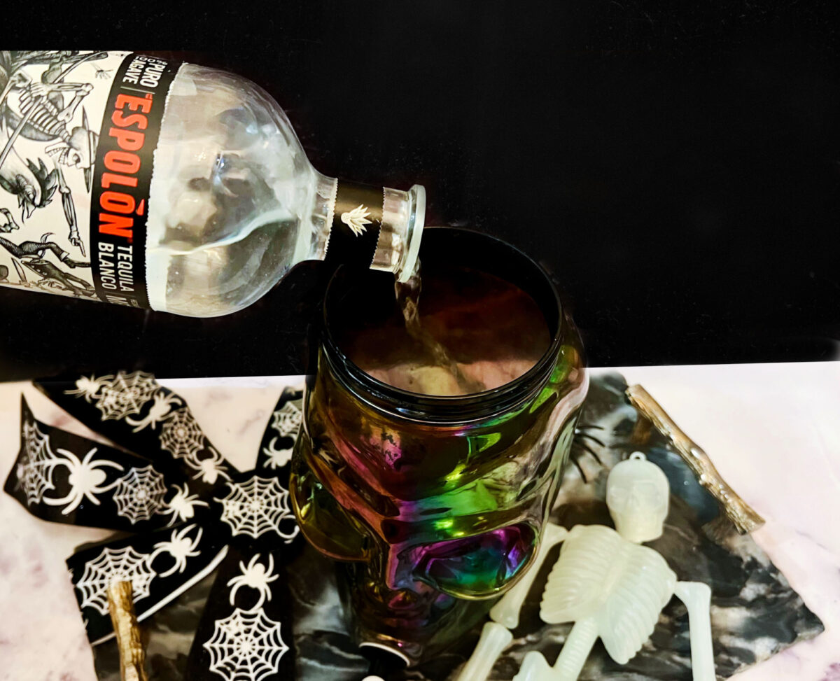 tequila being poured into a skull shaped pitcher