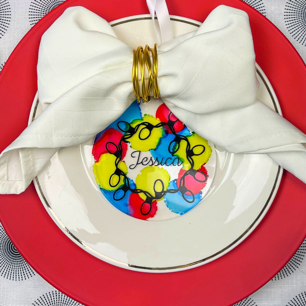 close up of a christmas lights place card on red and white plates