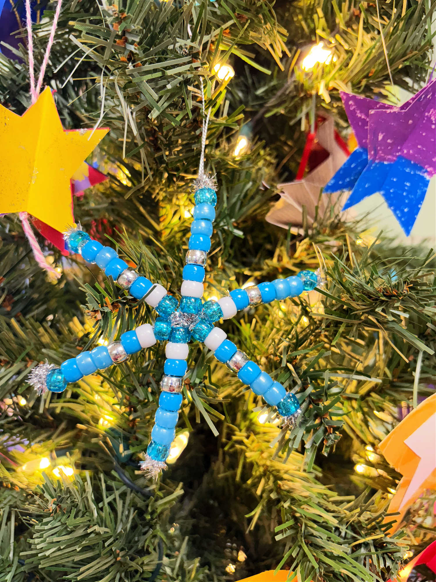 blue pony bead and pipe cleaner christmas ornament on a tree