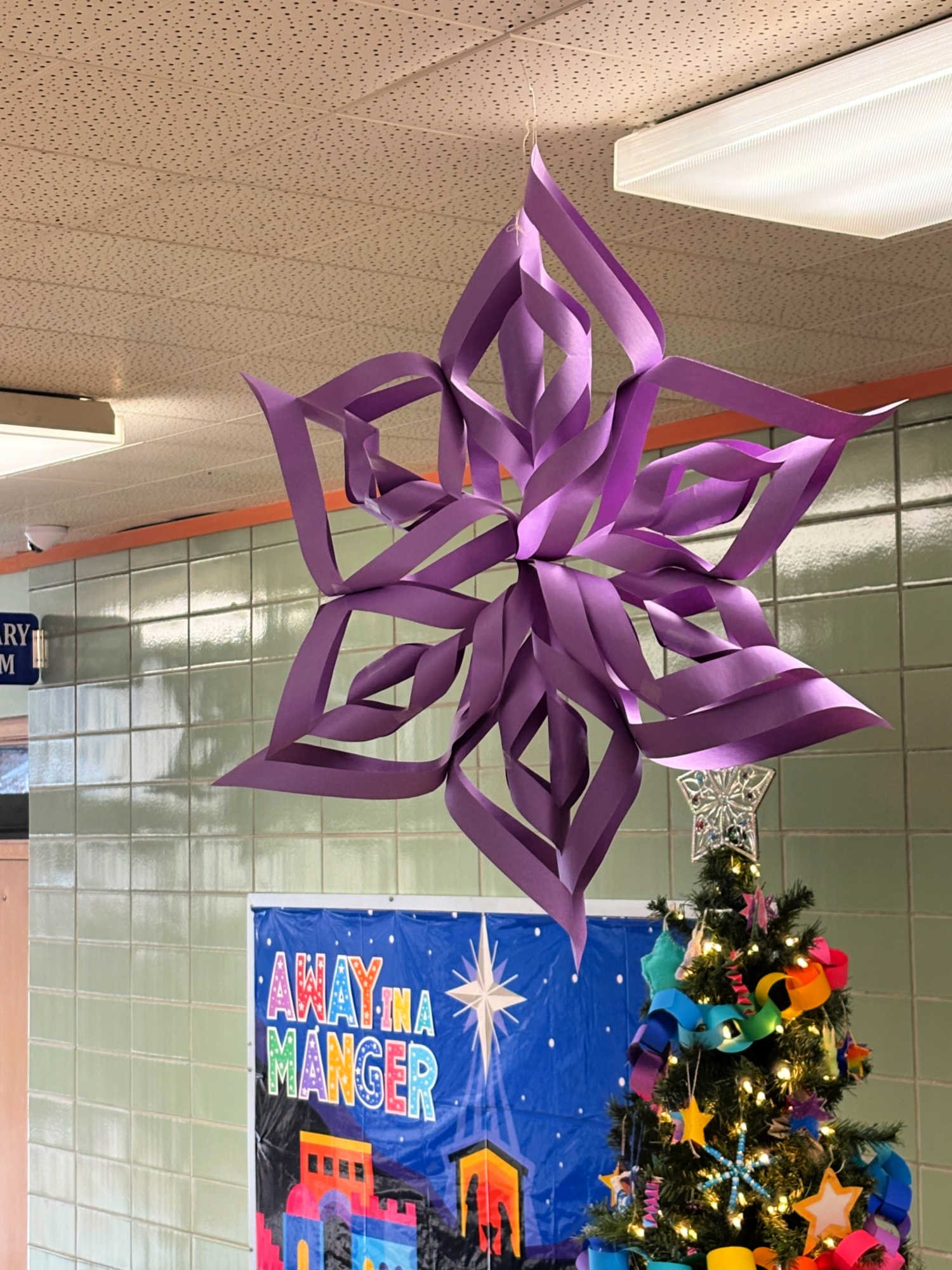 large purple paper star hanging from a ceiling