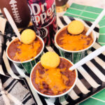 view of 3 small bowls of chili near a can of Dr. Pepper