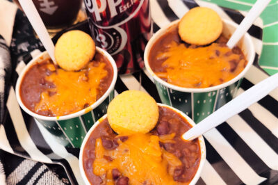 view of 3 small bowls of chili near a can of Dr. Pepper