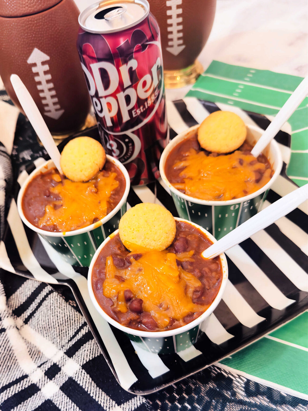 view of 3 small bowls of chili near a can of Dr. Pepper