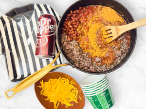 pot with chili ingredients near a can of Dr Pepper